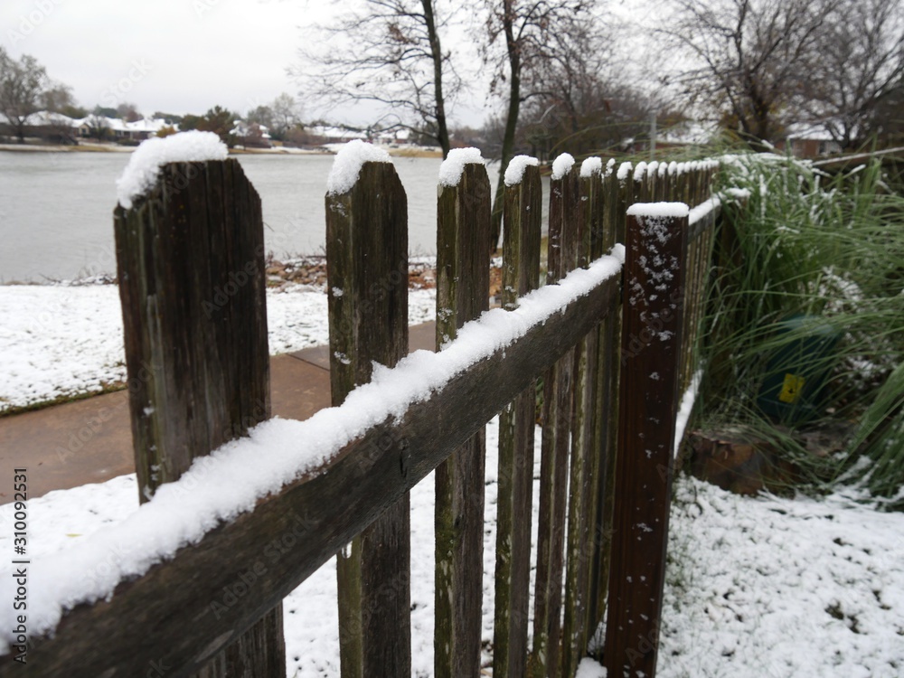 Medium wide shot of a wooden fence with snow on a winter morning Medium wide shot of a wooden fence with snow on a winter morning