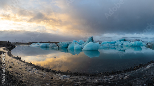 Dramatic sky over glacier lagoon with floating icebergs in Iceland