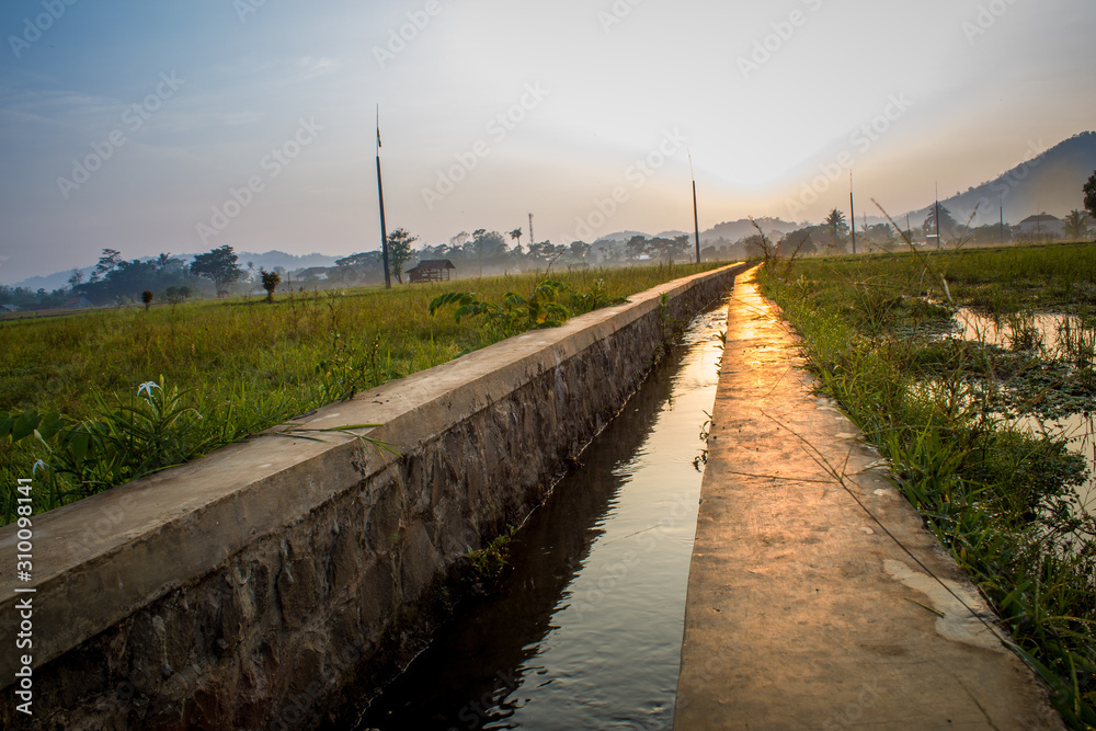 Footpath Amidst Canal Against Sky During Sunset