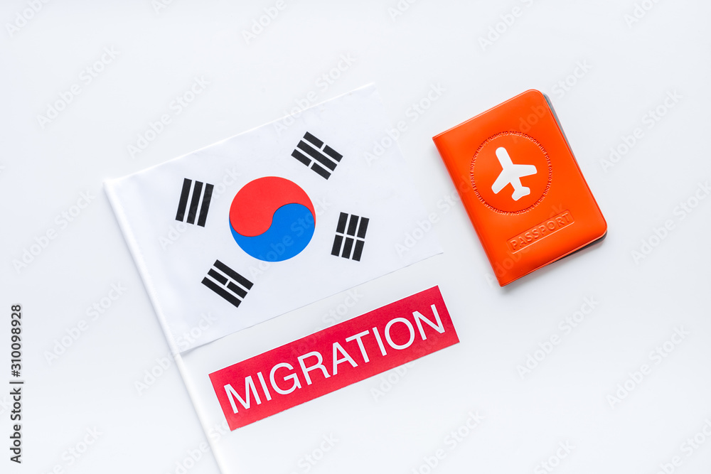 Migration to Korea concept. Korean flag near passport on white background top-down