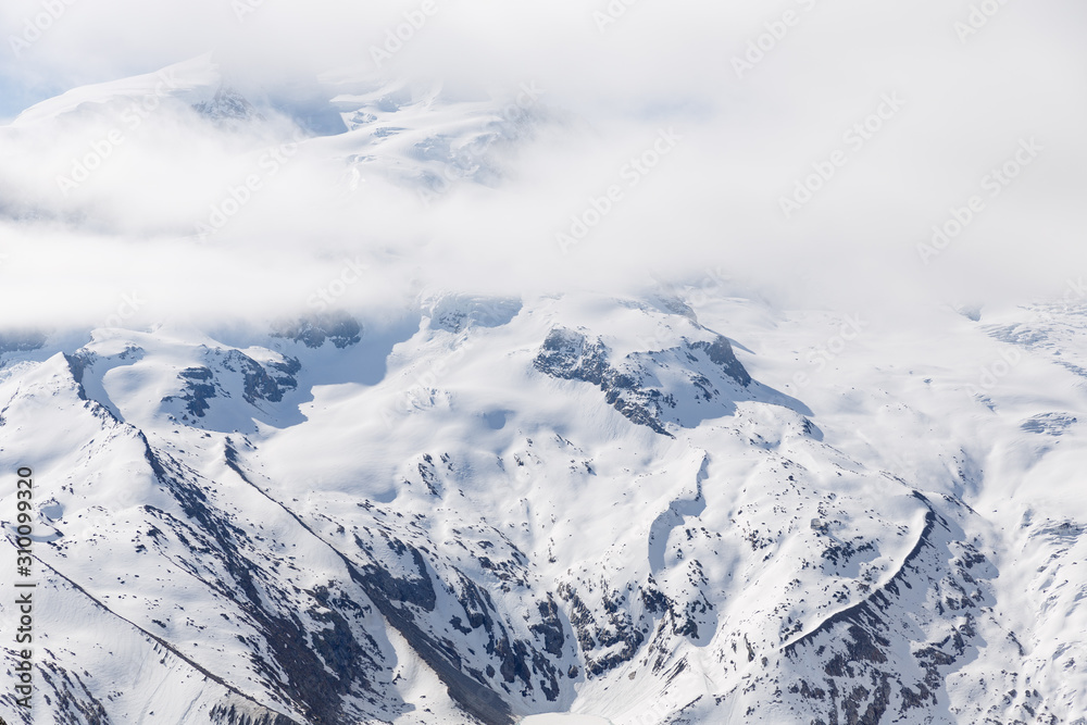 Alpine mountains under the snow during winter time, Switzerland.