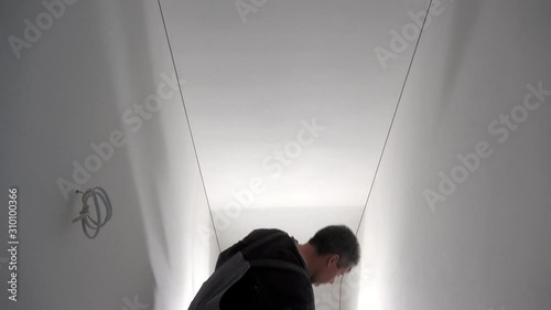 Professional worker with sandpaper in hand prepare wall surface for painting photo