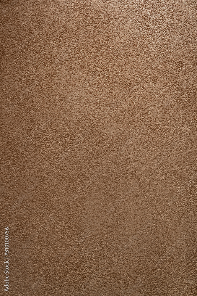Fototapeta premium Orange stucco material with light illuminated from top / background texture / interior material