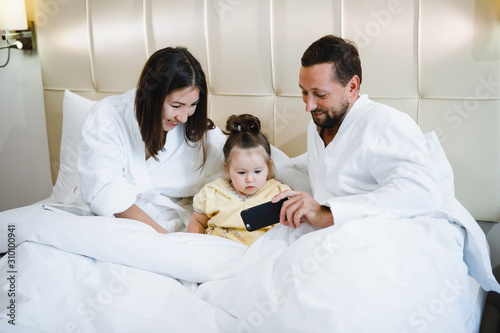 Mom, dad and daughter in bed.