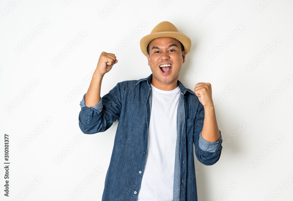 Asian men aged around 30 wearing hats and jeans feeling happy celebrate with two hand stretch on white background.