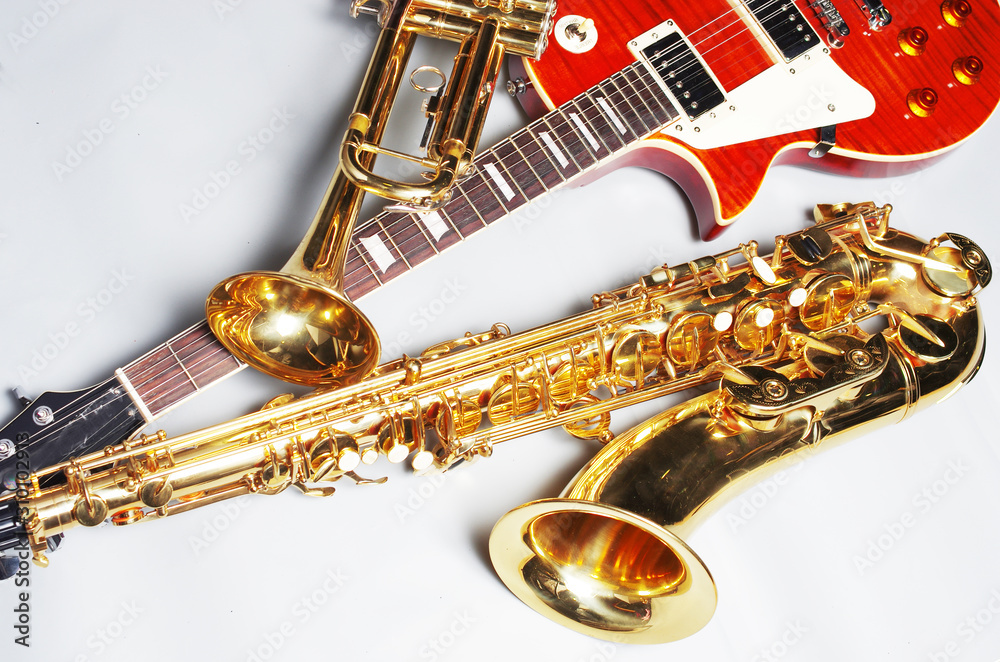 Obraz premium Electric guitar, trumpet and saxophone on a light background.