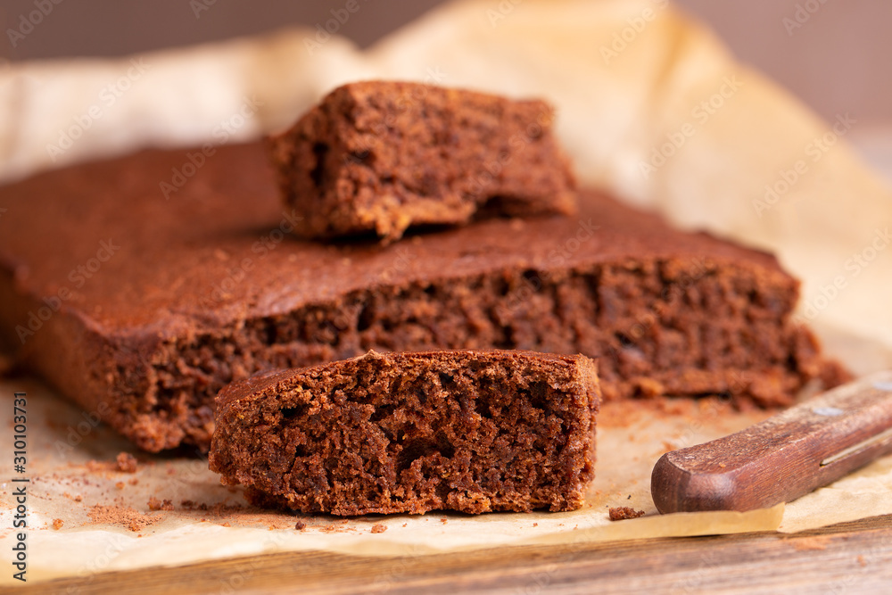 Freshly baked brownie pie on a wooden table. Chocolate cake close-up. Sliced Brownie. Freshly baked brownie pie on a wooden table. Chocolate cake close-up. Sliced Brownie.
