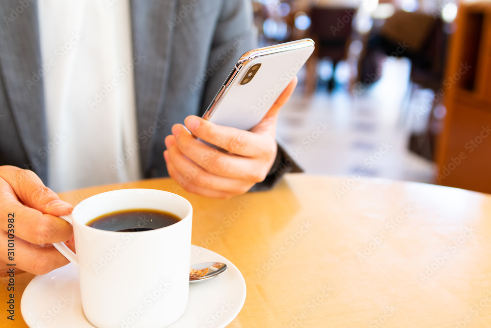 カフェでスマホを操作する女性 カフェでスマホを操作する女性