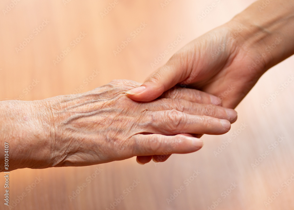 Young and old hands hold each other. The concept of love of a young and old generation of people. Young and old hands hold each other. The concept of love of a young and old generation of people.
