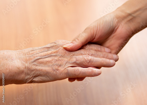 Young and old hands hold each other.  The concept of love of a young and old generation of people. © fortton