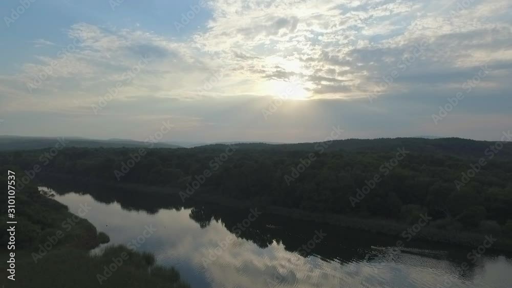 Flying over a river at sunrise
