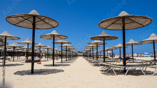 Marsa Matruh  Egypt. Rows of umbrellas made of straw and sunbeds. Sandy beach. Sunrise and early morning time. Relaxing context. Fabulous holidays. Mediterranean Sea. North Africa