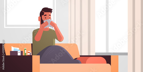 sick man blowing nose with handkerchief unhealthy guy cleaning snotty nose having flu sneeze sitting on sofa under blanket illness concept modern living room interior flat portrait horizontal vector