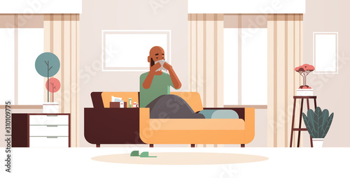 sick man blowing nose with handkerchief unhealthy african american guy cleaning snotty nose having flu sneeze sitting on sofa illness concept modern living room interior full length horizontal vector