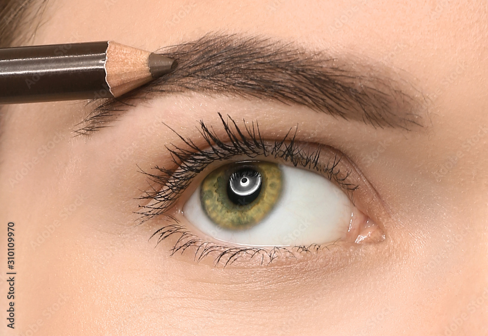 Naklejka premium Young woman undergoing eyebrow correction procedure, closeup
