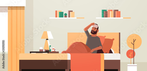 sick man with wet towel on forehead unhealthy guy reducing high fever suffering from cold flu virus lying on bed illness concept modern living room interior flat full length horizontal vector photo