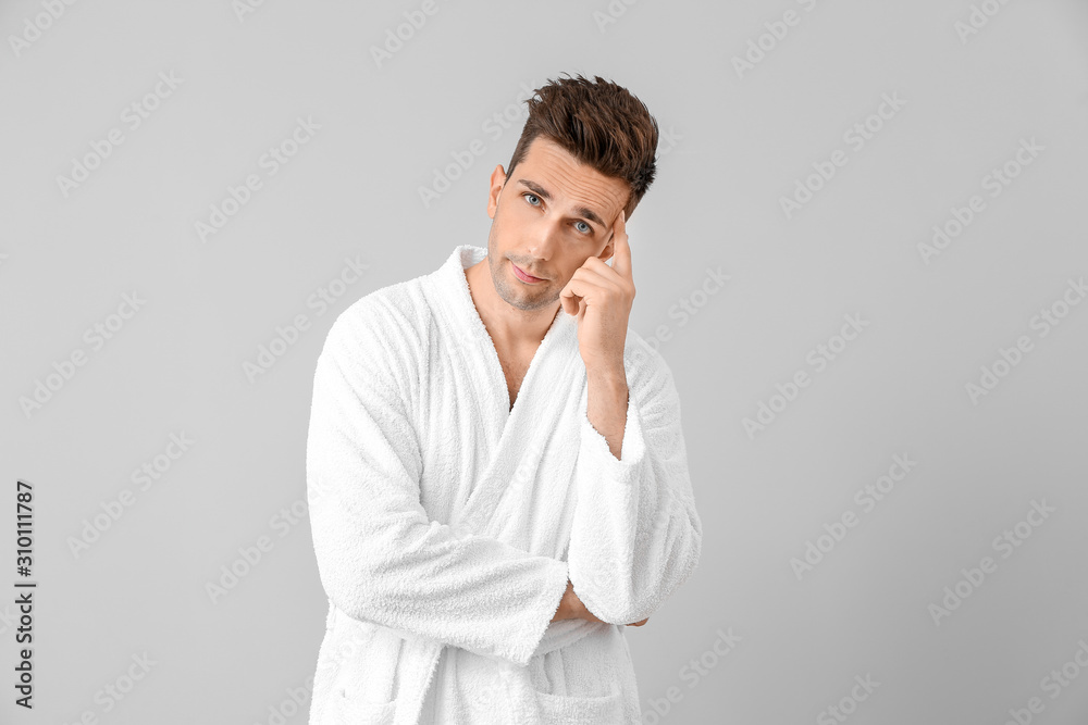 Handsome man in bathrobe on grey background Handsome man in bathrobe on grey background