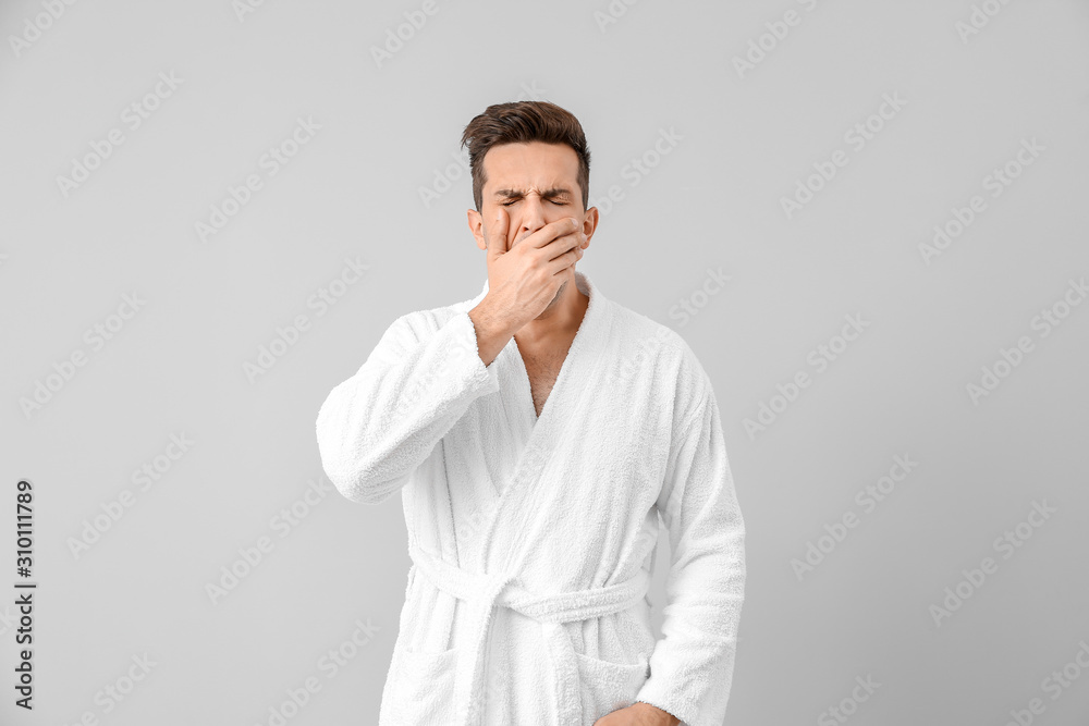 Sleepy man in bathrobe on grey background Sleepy man in bathrobe on grey background