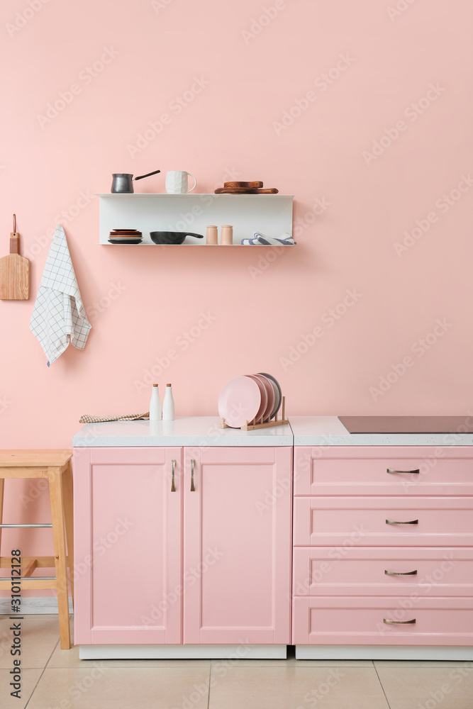 Interior of kitchen with modern shelf hanging on color wall Interior of kitchen with modern shelf hanging on color wall