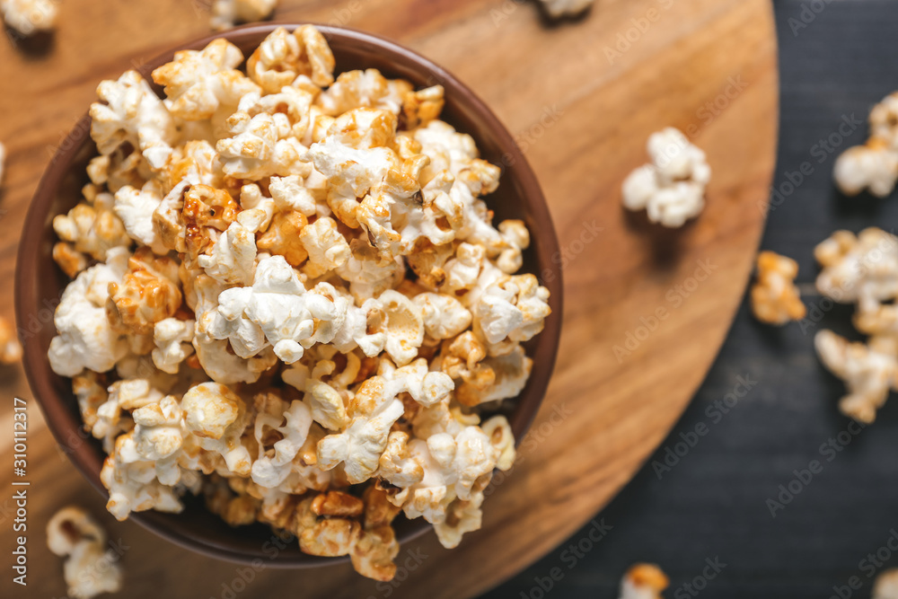 Bowl with tasty popcorn on table, closeup Bowl with tasty popcorn on table, closeup