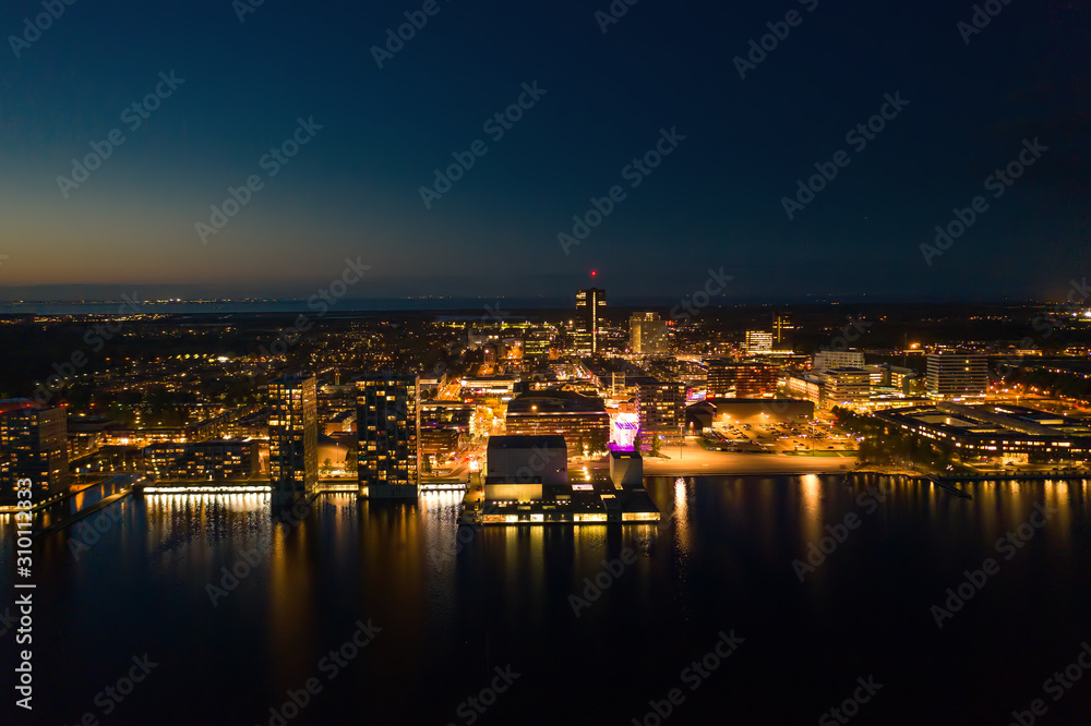 Almere city skyline at night/dusk. Aerial wide shot.