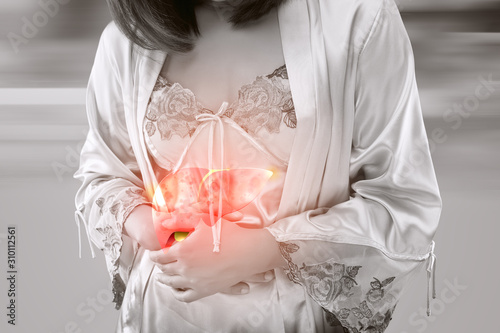 A woman in satin nightwear clutch the liver under bust photo