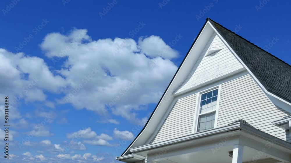 Time lapse footage of a modern house rooftop with blue sky and clouds passing by