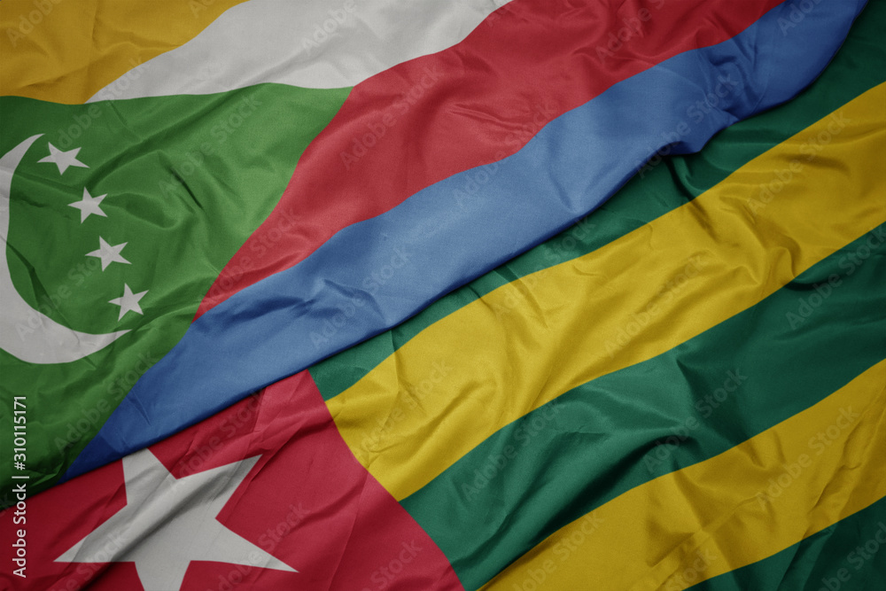 waving colorful flag of togo and national flag of comoros.