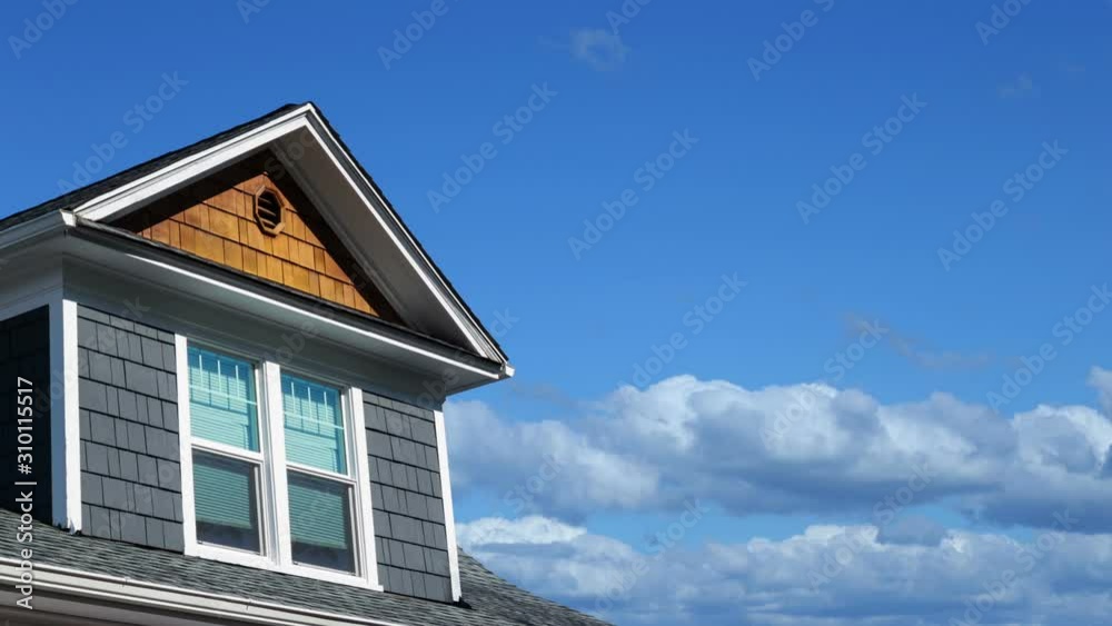 Time lapse footage of a modern house rooftop with blue sky and clouds passing by