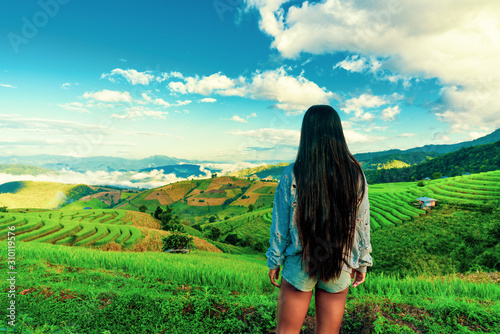 Young beautiful traveler woman with camera explore amazing rice terrace in Asia on background scenery nature landscape at sunrise. Active lifestyle and travel concept.