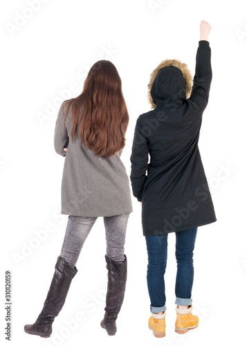 Back view of two pointing young girl in winter jacket.