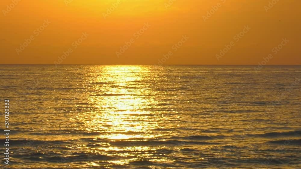 Golden ocean waves at sunrise, sunlight on rippled water Golden ocean waves at sunrise, sunlight on rippled water