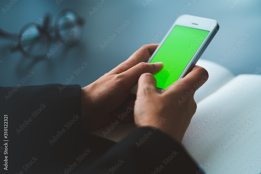 businessman using smart phone with green screen at office, connection concept