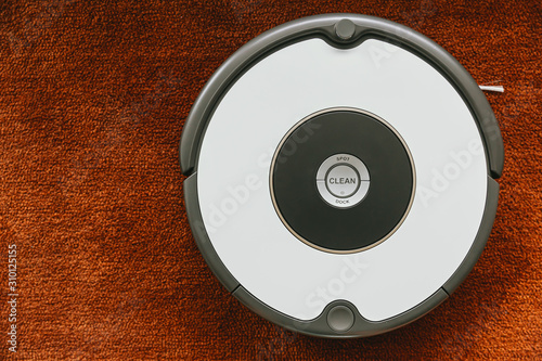 Robot vacuum cleaner on the floor working cleaning on carpet.