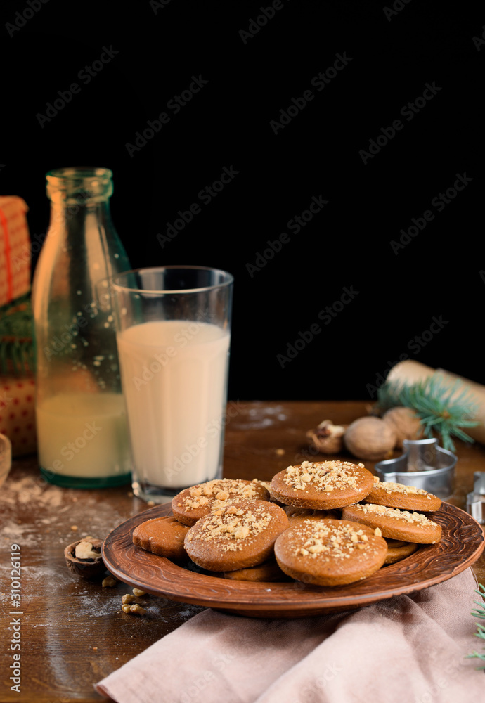 A glass of milk with Christmas cookies, nuts, gifts on the table. A glass of milk with Christmas cookies, nuts, gifts on the table.