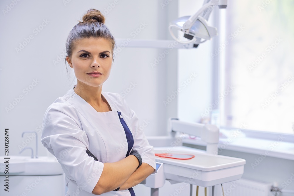 Young confident female dentist doctor with folded arms Young confident female dentist doctor with folded arms
