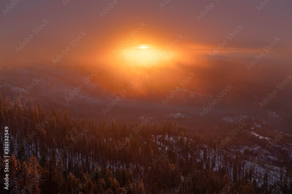 Sunset over misty mountain forest 