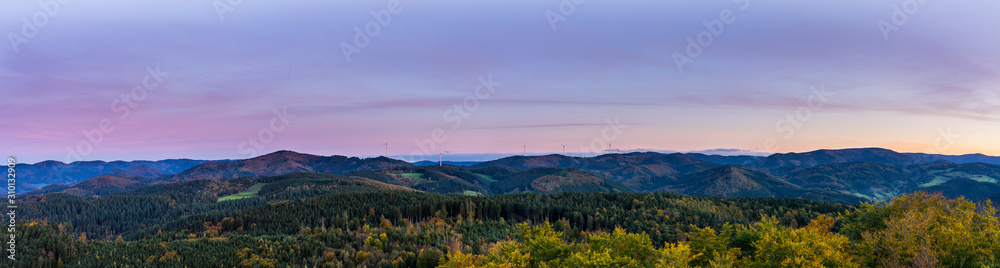 Germany, XXL panorama of endless untouched black forest nature landscape, hills and mountains under red glowing sky after sunset, aerial view above