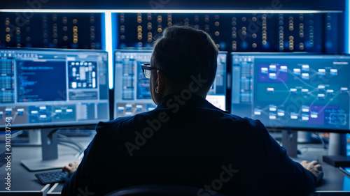 Professional IT Programer Working in Data Center on Desktop Computer with Three Displays, Doing Development of Software and Hardware. Displays Show Blockchain, Data Network Architecture Concept photo
