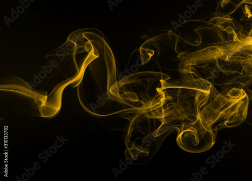 yellow smoke abstract on black background, yellow ink on dark