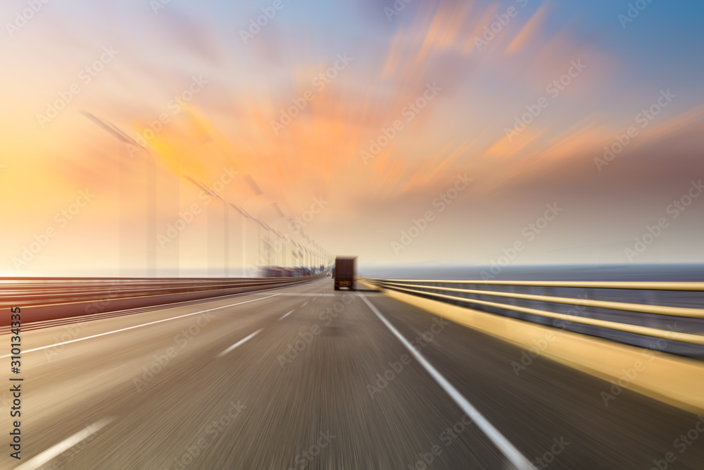Blurred motion of truck and asphalt road at dusk