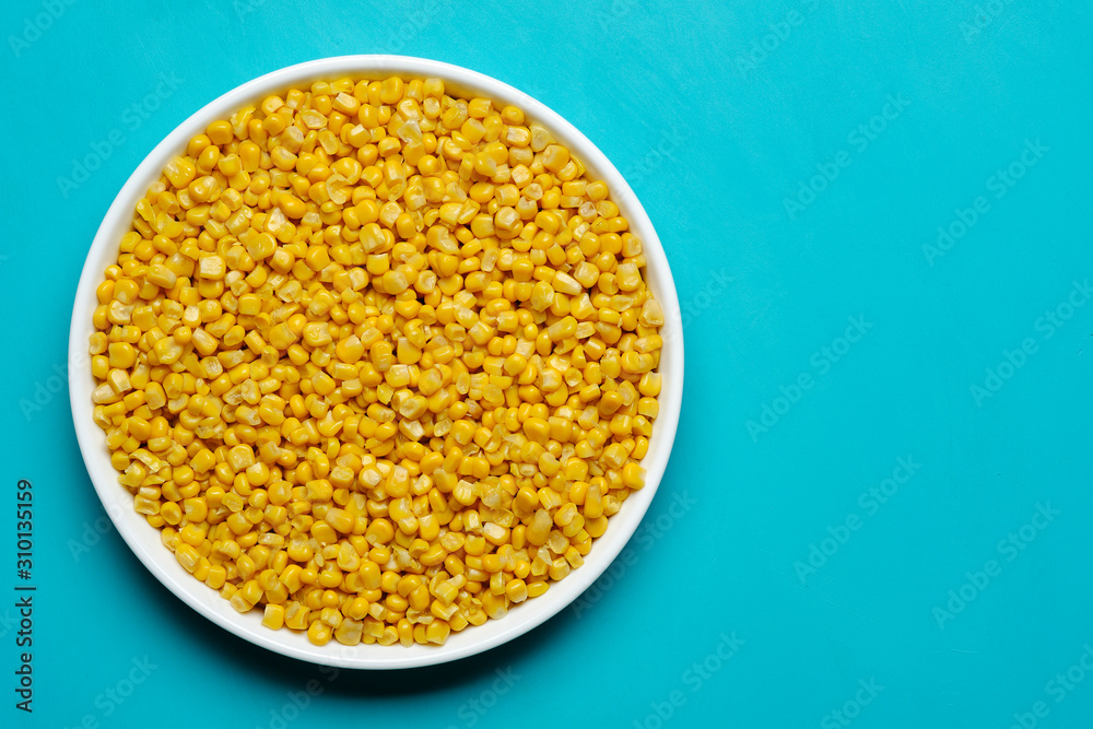 canned corn in white plate top view. turquoise, light blue background canned corn in white plate top view. turquoise, light blue background