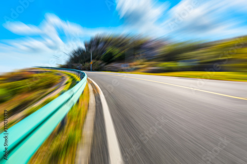 Blurred moving asphalt road and nature landscape during the day