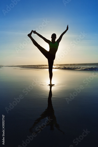 Black silhouette of active woman stretching at yoga retreat on sunset beach  sky with sun  ocean surf background. Travel lifestyle  people outdoor activity  family summer vacation on tropical island.