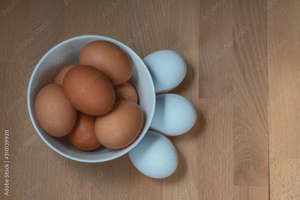 several fresh chicken eggs in a ceramic cup on a wooden background. Healthy eating concept several fresh chicken eggs in a ceramic cup on a wooden background. Healthy eating concept