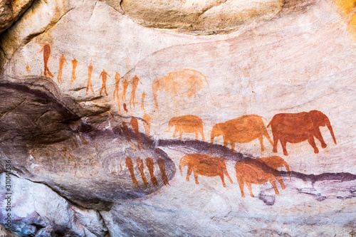Rock art painting of the bushmen San at Stadsaal, Cederberg, South Africa, showing a group of elephants and men