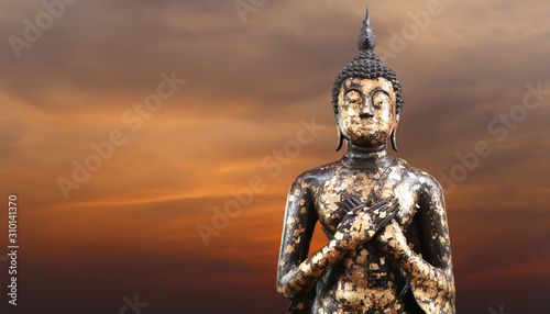 Buddha statue on twilight sky background.