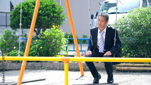 ブランコに乗る中高年男性 Stock Photo Adobe Stock