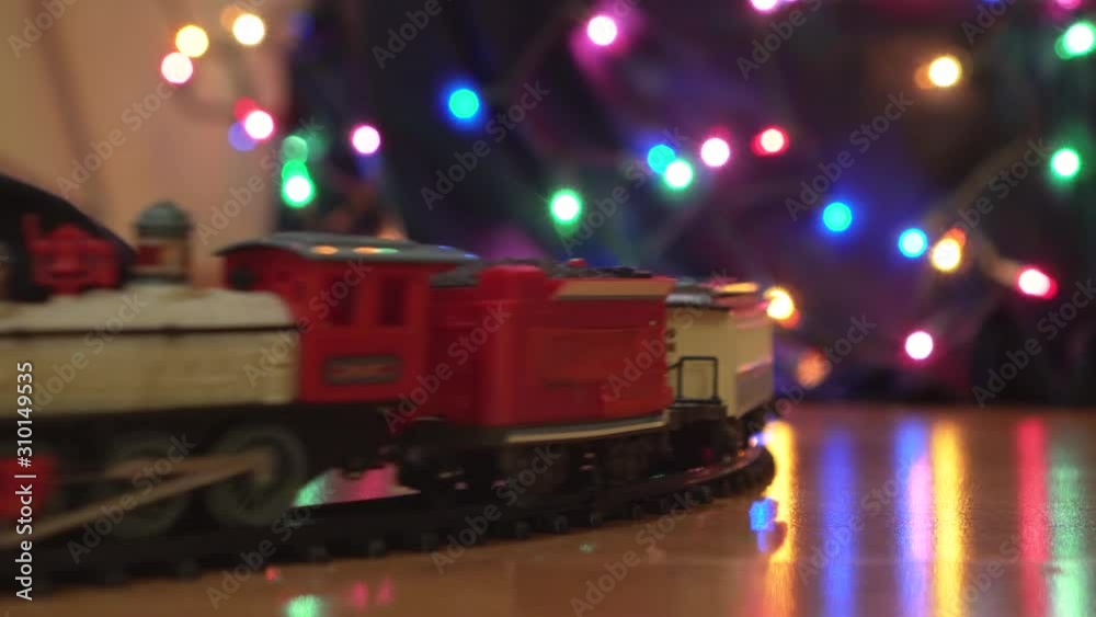 Close Up of Toy Train Going Around Decorated Christmas Tree