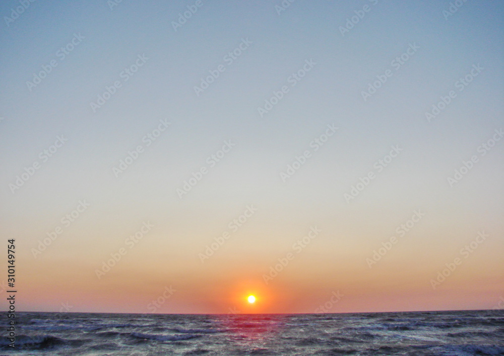 Obraz premium Incredible natural picture of a colorful sky over the stormy blue infinity of the Azov Sea at dawn.